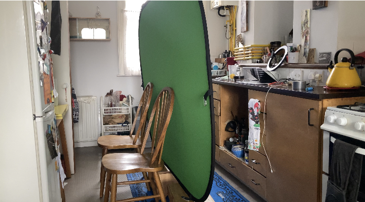 Blue screen on 2 stools, leaning against 2 chairs, in front of a kitchen counter loaded with stuff. And, from this I booked my first acting TV job.